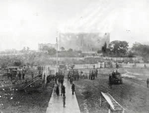 Photograph of Capitol Building burning with crowds gathered in foreground