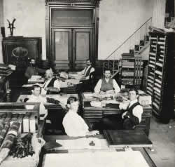 Photograph of men seated at desks in office of the Comptroller's Department