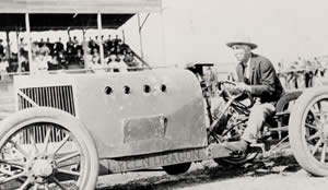 Photograph of older man behind wheel of racecar