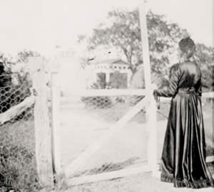 Photograph of woman standing at entrance to Mrs. Ney's studio grounds