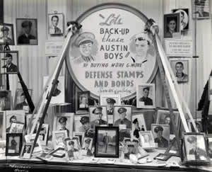 Photograph of store display window filled with many framed portraits of local U.S. Servicemen