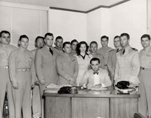 Photograph of group of uniformed men standing behind Lyndon Johnson