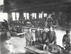 Photograph of workers learning about automobile construction